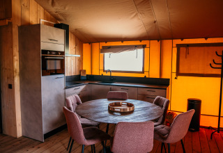 Alojamiento glamping moderno en Strandpark De Zeeuwse Kust con cocina y comedor en tienda safari en Zeeland.