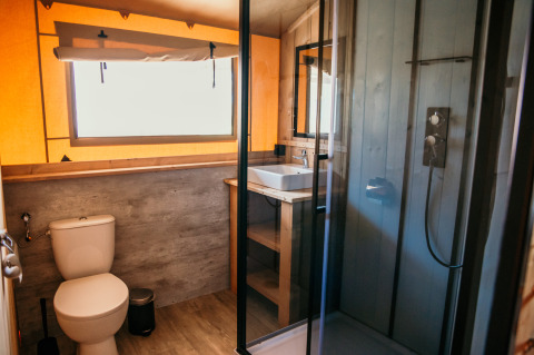 Moderne badeværelse med toilet, bruser og håndvask i glamping safari telt på Strandpark De Zeeuwse Kust.