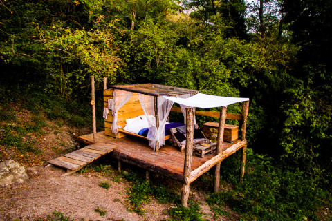 Outdoor glamping accommodation at Novanta Skylodge in Italy, wooden platform nestled in nature.