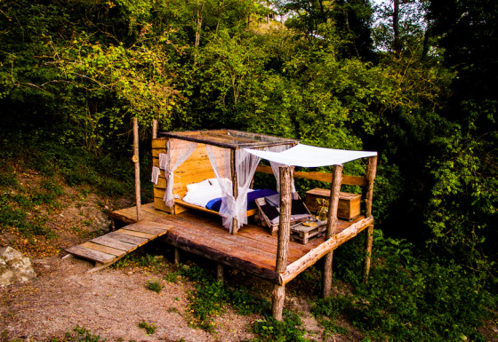 Hébergement glamping en plein air au Novanta Skylodge en Italie, plateforme en bois entourée de nature.
