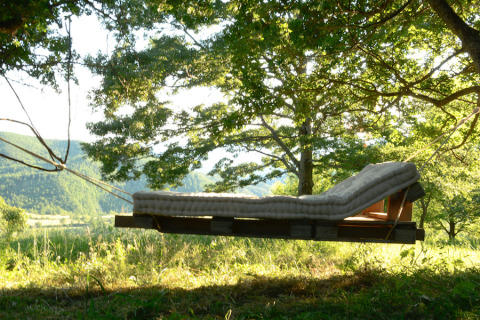 Lit suspendu avec matelas sous les arbres, Novanta Skylodge - Italie, hébergement glamping nature.