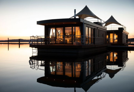 Drijvende lodge bij valavond in Floating Village Brombachsee, luxe glampingverblijf in Beieren, Duitsland.
