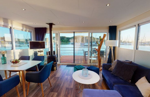 Moderna sistemazione glamping al Floating Village Brombachsee con interni eleganti e vista lago in Baviera.