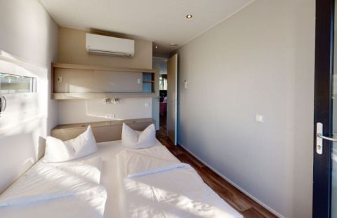 Hébergement glamping moderne au Floating Village Brombachsee - Lodges Bayern avec lit double confortable.