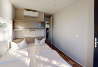 Moderne glamping accommodatie bij Floating Village Brombachsee - Lodges Bayern met een comfortabel bed.