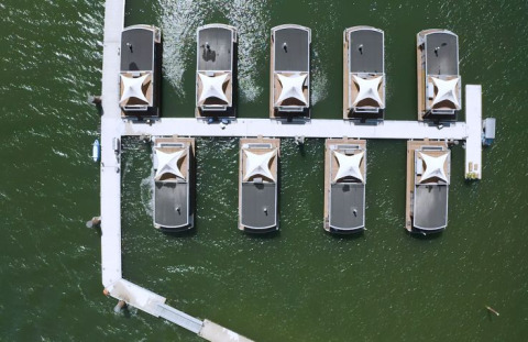 Vista aérea de lodges glamping en Floating Village Brombachsee, Baviera, sobre aguas verdes.