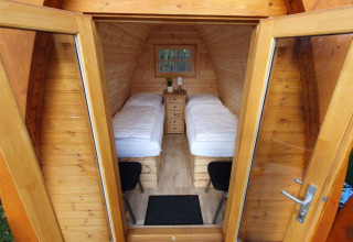 Innenansicht einer Holz-Camping-Pod mit zwei Einzelbetten im Campotel Nord-Ostsee, Schleswig-Holstein.