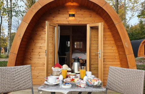 Campotel Nord-Ostsee Pods in Schleswig-Holstein with breakfast set on a table in front of a wooden pod.