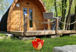 Holz-Pod-Unterkunft mit Terrasse und Gartenmöbeln bei Campotel Nord-Ostsee - Pods Schleswig-Holstein im Grünen.
