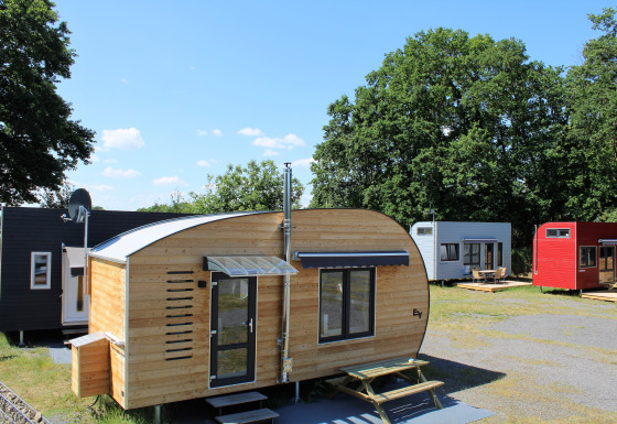 Several modern wooden and colorful tiny houses at the Klein vakantie- en tentoonstellingspark glamping site in Lower Saxony.