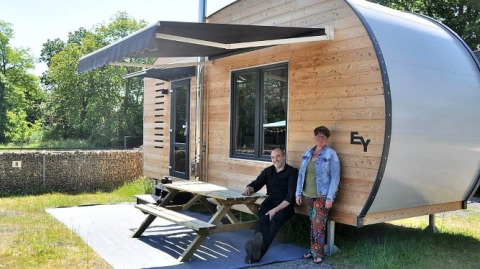 Twee personen bij een moderne glamping tiny house op Klein vakantie- en tentoonstellingspark in Nedersaksen.