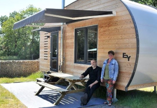 Deux personnes devant une tiny house moderne au glamping Klein vakantie- en tentoonstellingspark en Nedersaksen.