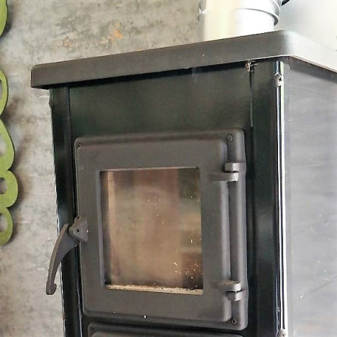 Stufa a legna nera con sportello in vetro in alloggio glamping a Klein vakantie- en tentoonstellingspark, tiny houses.