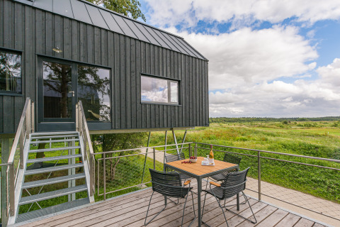Moderne trælodge ved Lütetsburg Lodges - Boomhutten Nedersaksen med udendørs terrasse og naturskøn udsigt.