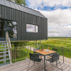 Contemporary cabin at Lütetsburg Lodges - Boomhutten Nedersaksen with deck seating and scenic field views.