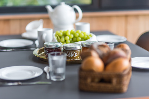 Petit-déjeuner à Lütetsburg Lodges - Boomhutten Nedersaksen avec petits pains, raisins et confitures.