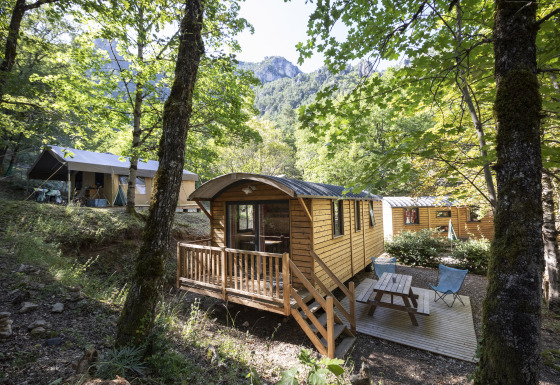 Sistemazioni glamping in cabine di legno e tende tra gli alberi a Huttopia Gorges du Tarn, Midi-Pirenei.