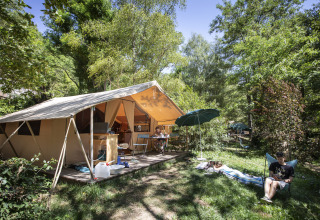 Glamping-Unterkunft bei Huttopia Gorges du Tarn im Midi-Pyrénées mit Zelt, Terrasse und entspannten Gästen.