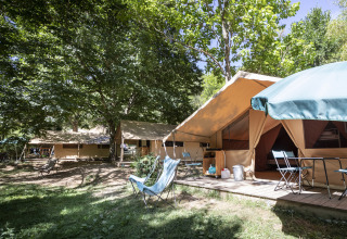 Glamping accommodation with large canvas tents and outdoor seating at Huttopia Gorges du Tarn in Midi-Pyrénées.