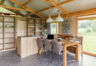 Moderne glampingaccommodatie met open keuken en eettafel bij Glamping - Landrijk de Reesprong.