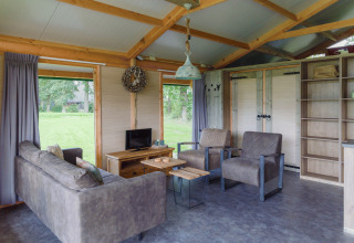 Intérieur d'un hébergement glamping chez Landrijk de Reesprong, mobilier confortable, vue sur la nature.