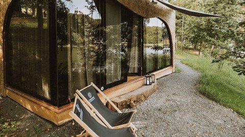 Glamping bij Falkensteiner Premium Camping Blaguš – Glamping Slovenië met stoelen en bosrijke omgeving.