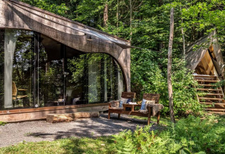 Glamping accommodatie bij Falkensteiner Premium Camping Blaguš, Slovenië, met moderne glazen cabins in het bos.