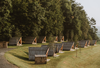 Row of modern glamping cabins by the forest at Falkensteiner Premium Camping Blaguš in Slovenia.
