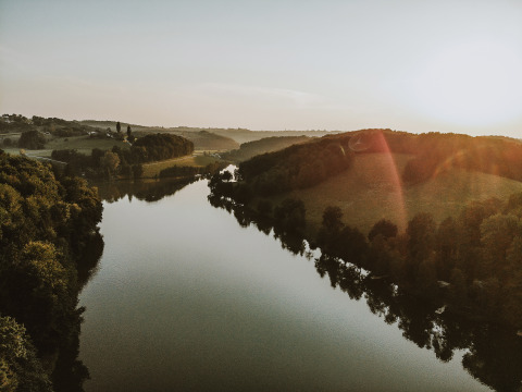 Wunderschöner Sonnenuntergang über einem Fluss bei Falkensteiner Premium Camping Blaguš - Glamping Slowenien.