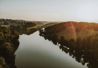 Prachtige zonsondergang boven rivier bij Falkensteiner Premium Camping Blaguš - Glamping Slovenië.