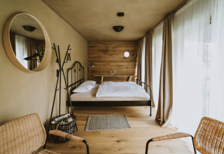 Luxe glampingverblijf met zwevend bed, hoge ramen en minimalistisch interieur bij Falkensteiner Premium Camping Blaguš.
