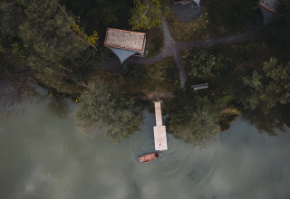Luftaufnahme von Falkensteiner Premium Camping Blaguš Glamping Slowenien mit Steg, Boot und Zelthütten.