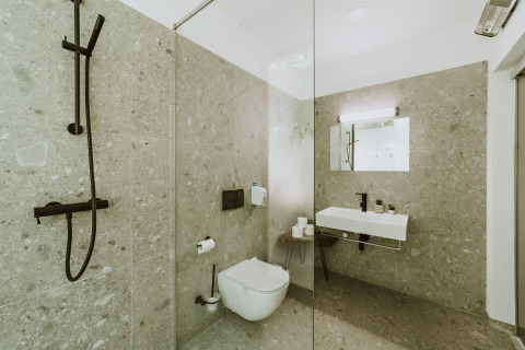 Moderne badkamer bij Falkensteiner Premium Camping Blaguš Glamping Slovenië met regendouche en wastafel.