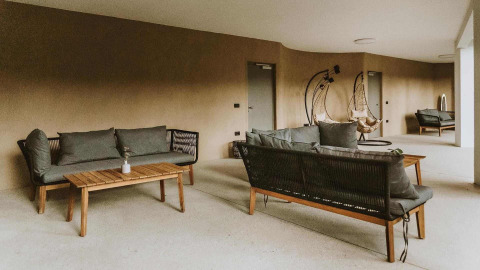 Zona lounge all'aperto con divani moderni e poltrone sospese al Falkensteiner Premium Camping Blaguš Glamping Slovenia.