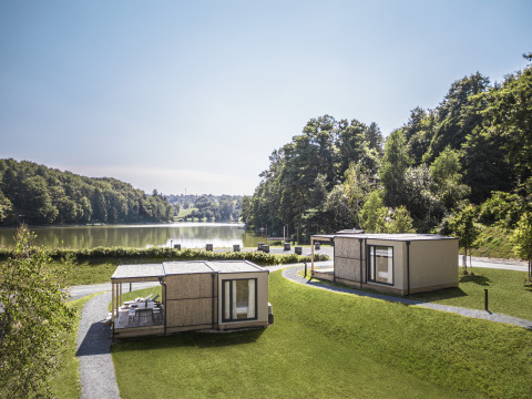 Hébergements glamping au Falkensteiner Premium Camping Blaguš au bord d’un lac entouré de verdure en Slovénie.