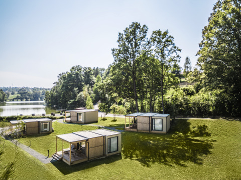 Cuatro pequeñas cabañas de glamping junto a un lago rodeadas de naturaleza en Falkensteiner Premium Camping Blagus, Eslovenia.