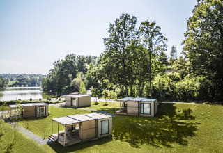 Quattro piccole cabine glamping vicino al lago circondate dal verde al Falkensteiner Premium Camping Blagus, Slovenia.
