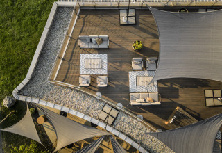 Luftaufnahme von Falkensteiner Premium Camping Blaguš Glamping mit modernen Terrassenmöbeln und Sonnensegeln.