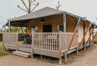 Glamping-Unterkunft in De Betuwse Hofjes - Ranger Lodges Gelderland mit Holzveranda und Zelt.