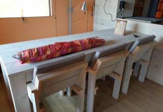 Et spisebord med stærke træstole i glamping-indkvartering på De Betuwse Hofjes - Ranger Lodges Gelderland.