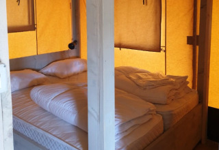 Indvendig billede af glamping indkvartering med komfortable senge hos De Betuwse Hofjes - Ranger Lodges Gelderland.