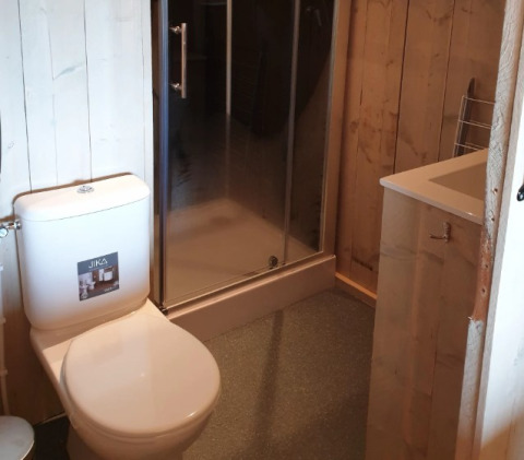 Badezimmer mit Toilette, Dusche und Waschbecken in De Betuwse Hofjes - Ranger Lodges Gelderland Camping.