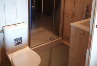 Baño con inodoro, ducha y lavabo en De Betuwse Hofjes - Ranger Lodges Gelderland alojamiento glamping.