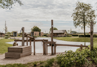 Glamping ved søen hos De Betuwse Hofjes - Ranger Lodges Gelderland med trælegetøj og naturskøn udsigt.