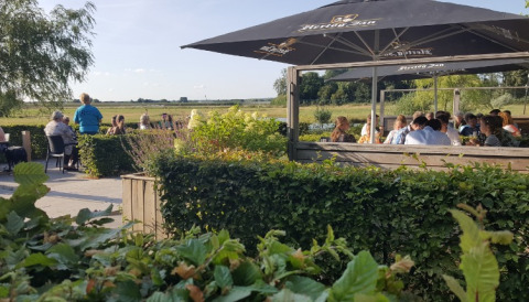 Outdoor dining area at De Betuwse Hofjes - Ranger Lodges Gelderland with green views and happy guests.