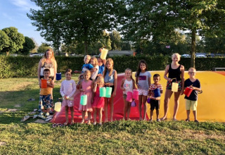 Kinderen en volwassenen met kleurrijke lampionnen op een luchtkussen bij De Betuwse Hofjes Ranger Lodges Gelderland.