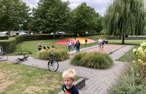 Des enfants jouent dehors à De Betuwse Hofjes - Ranger Lodges Gelderland, site de camping convivial.