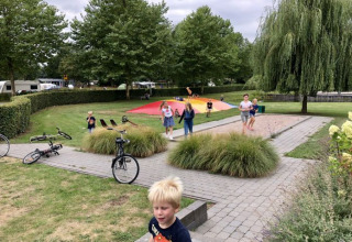 Bambini che giocano all'aperto a De Betuwse Hofjes - Ranger Lodges Gelderland, una zona campeggio.