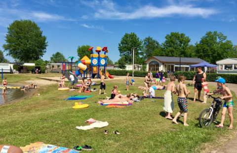 Gezinnen genieten van buitenplezier bij De Betuwse Hofjes - Ranger Lodges Gelderland met speeltuin en meer.