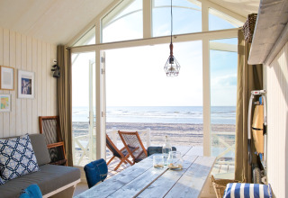 Knus strandhuisje met modern interieur, grote ramen en zeezicht bij HaagseStrandhuisjes in Den Haag.